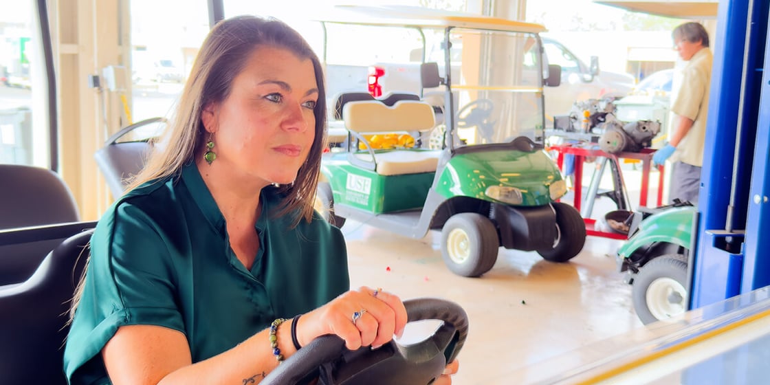 Lincey Araya pulls a golf cart into the service bay.