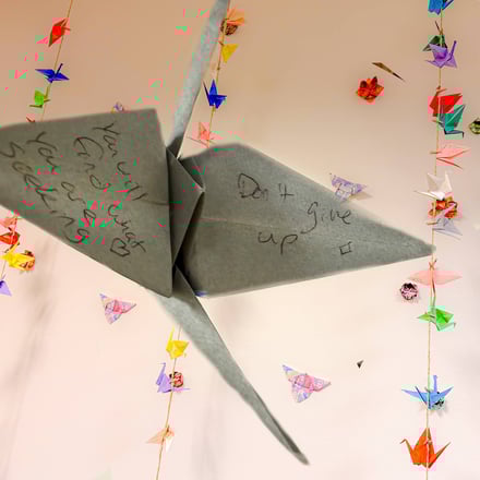 Paper cranes display warm, positive messages at the entrance.