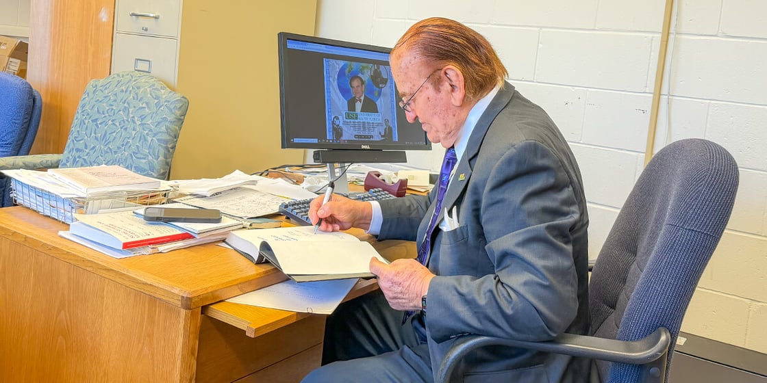 Chris P. Tsokos at his desk before a weekly meeting with eo